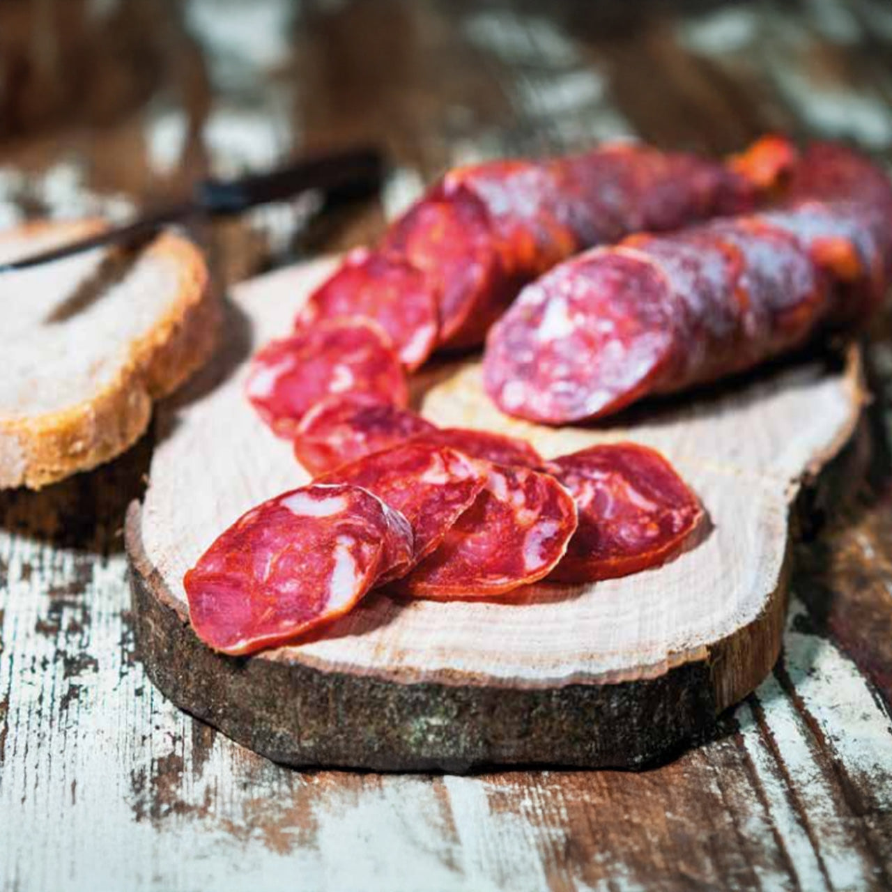 Salsiccia cilentana Diano salumi tagliata a fette e posta su un tagliere in legno